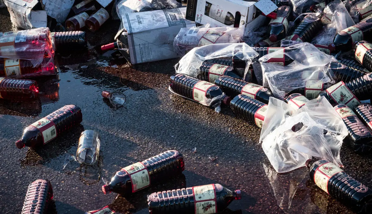 Minuman anggur ditumpahkan saat aksi protes di sebuah hypermarket di Nimes, Perancis, Kamis (20/4). Pedagang minuman Perancis marah karena harga minuman anggur dari Spanyol terlampau murah. (AP Photo / Arnold Jerocki)