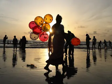 Seorang wanita menjual balon di Pantai Juhu, Mumbai, India, Selasa (24/8/2021). India mencatat penambahan 14.419 kasus positif COVID-19 pada 24 Agustus 2021. (AP Photo/Rafiq Maqbool)
