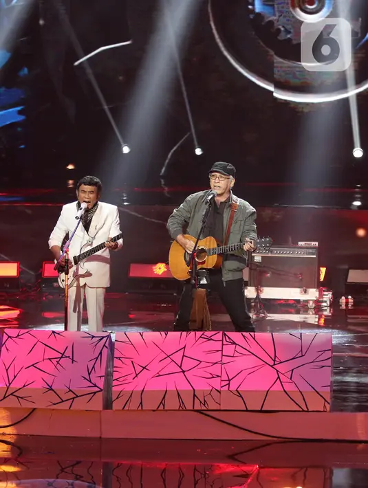 Penampilan penyanyi Rhoma Irama (kiri) dan Iwan Fals saat konser Pesta Perak 25 Indosiar di Jakarta, Minggu (12/1/2020). Rhoma Irama dan Iwan Fals berkolaborasi membawakan lagu Mirasantika, Buku Ini Aku Pinjam, Judi, dan Santai. (Liputan6.com/Herman Zakharia)