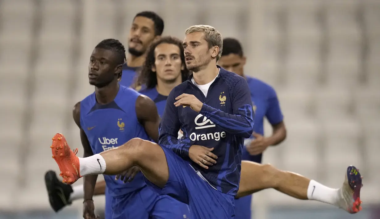 Penyerang Prancis, Antoine Griezmann bersama rekan setimnya melakukan pemanasan selama sesi latihan di stadion Jassim Bin Hamad di Doha, Qatar, Senin, 12 Desember 2022.  Ini akan menjadi semifinal ketujuh bagi Prancis sepanjang gelaran Piala Dunia. (AP Photo/Christophe Ena)