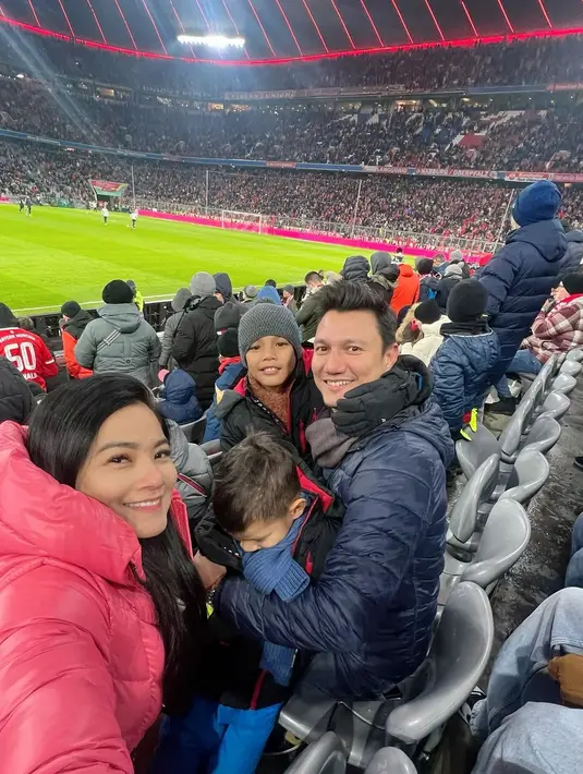 Selain membagikan momen menikmati liburan di Switzerland, Swiss, Titi Kamal juga membagikan di Allianz Arena menyaksikan bundesliga Jerman. "Akhirnya Juna kesampaian nonton bola di Alianz Arena 😍dingin banget🥶 demi anak gpp deh. Bocil heboh banget sepanjang acara." tulis Titi Kamal. [Instagram/titi_kamall]