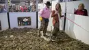 Miss Texas Margana Wood didampingi pawang ular berada di dalam kandang penuh ular derik saat acara Swingter Rattlesnake Sweetwater di Nolan County Coliseum (10/3). Dalam acara ini ribuan ular derik berbisa dikumpulkan di sebuah kandang. (AFP/Loren Elliot)