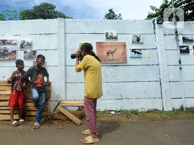 Anak-anak belajar memotret dengan kamera DSLR saat kegiatan pameran Lensa Anak Terminal di Sekolah Master, Depok, Jawa Barat, Rabu  (8/2/2023). Pameran 170 karya foto dari 12 anak-anak terminal di kawasan tersebut merupakan hasil pembelajaran bersama Komunitas Lensa Anak Terminal dan berlangsung  hingga 12 Februari 2023. (merdeka.com/Arie Basuki)