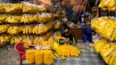 Seorang wanita membuat karangan bunga marigold menjelang Loy Krathong di pasar bunga Pak Khlong Talat, Bangkok, Kamis (18/11/2021). Bulan November ini Thailand akan mengadakan festival Loy Krathong di mana warga menghanyutkan keranjang berisi bunga dan lilin di sungai atau danau. (Jack TAYLOR/AFP)