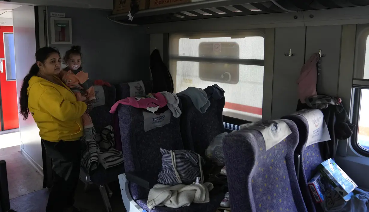 Seorang perempuan dengan seorang anak tertahan di dalam kereta api, sebagai tempat berlindung, di kota Iskenderun, Turki selatan, Selasa (14/2/2023). Korban tewas gempa Turki dan Suriah telah menembus 41 ribu jiwa. Masifnya korban tewas ini membuat gempa Turki disebut sebagai "bencana alam terburuk" dalam satu abad terakhir di Eropa. (AP Photo/Hussein Malla)