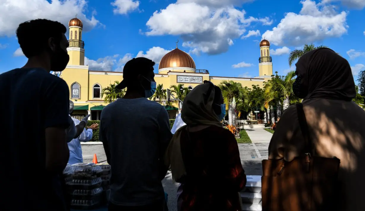 Para relawan Asosiasi Komunitas Muslim Miami dan Yayasan Lumba-Lumba Miami mendistribusikan makanan buka puasa Ramadhan di Miami Gardens, Florida, Amerika Serikat, Selasa (27/4/2021). Distribusi makanan dilakukan secara drive thru. (CHANDAN KHANNA/AFP)