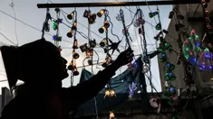 Seorang wanita berbelanja lampu hias dan lentera di sebuah toko di Deir al-Balah di pusat kota Gaza, ketika umat Islam bersiap untuk bulan puasa Ramadan pada 3 Maret 2024. (Foto: AFP)
