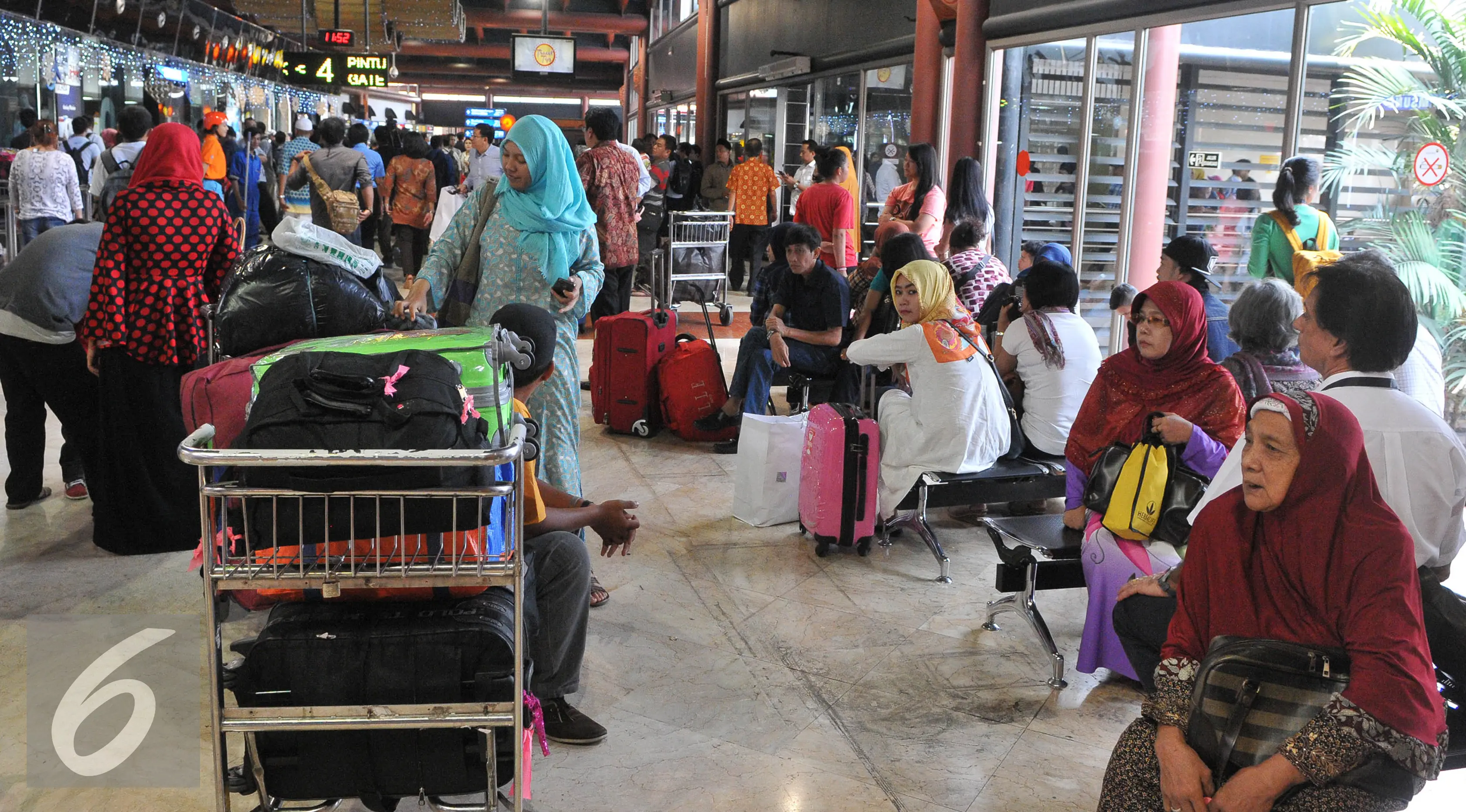 Sejumlah calon penumpang menunggu keberangkatan di terminal 2E Bandara Soekarno Hatta, Tangerang, Senin (6/7/2015). Pasca insiden kebakaran pada Minggu (5/6) lalu, situasi terminal 2E Bandara Soekarno Hatta mulai normal. (Liputan6.com/Herman Zakharia)