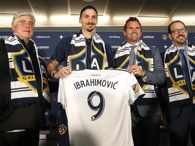 Mantan Striker Manchester United, Zlatan Ibrahimovic, berpose bersama petinggi LA Galaxy saat perkenalan di StubHub Center, AS, Sabtu (30/3/3028). LA Galaxy menjadi klub kesembilan sepanjang karier pria Swedia ini. (AP/Ringo H.W. Chiu)