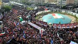 Foto-foto komandan militer dan ilmuwan Iran yang tewas selama serangan Israel dipajang di Lapangan Enqelab ketika truk-truk yang membawa peti jenazah mereka melintas di ibu kota Teheran pada 28 Juni 2025. (ATTA KENARE/AFP)
