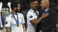 Isco (kiri) dan Casemiro tertawa bersama Zidane usai meraih trofi Liga Champions 2018 di Olympic Stadium, Kiev, Ukraina, (26/5/2018). Zinedine mundur sebagai pelatih Madrid 31 Mei 2018. (AFP/Paul Ellis)