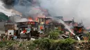 Petugas pemadam kebakaran berusaha memadamkan api yang membakar kawasan kumuh di Manila, Filipina (11/8). Api yang membakar pemukiman selama tiga jam tersebut menelan 300 rumah. (AP Photo/Bullit Marquez)