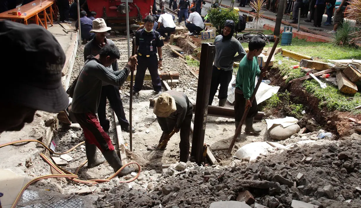 Sejumlah pekerja PT KAI langsung melakukan perbaikan pembatas antara rel dan ruang tunggu penumpang di Stasiun Kota, Jakarta, yang rusak dihantam lokomotif, Jumat (26/12/2014). (Liputan6.com/Faizal Fanani)