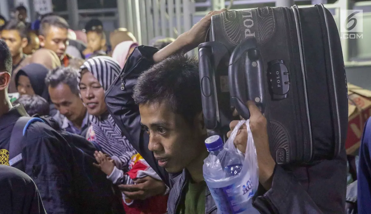 Pemudik mengangkut barangnya saat memasuki kapal penyebrangan menuju pelabuhan Bakauheni di Dermaga 1 Pelabuhan Penyebrangan Merak, Banten, Sabtu (1/6/2019). Hingga Sabtu (1/6) pukul 08.00 WIB, tercatat 400.309 orang menyebrang dari pelabuhan Merak menuju Bakauheni. (Liputan6.com/Helmi Fithriansyah)