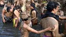 Warga melumuri seluruh tubuhnya dengan lumpur saat mengikuti tradisi Mebuug-Buugan. (SONNY TUMBELAKA/AFP)