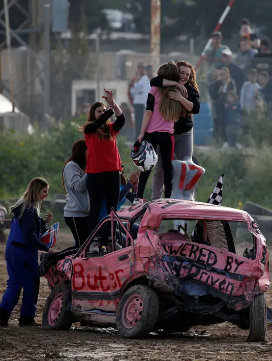 Pembalap yang keluar sebagai juara mendapat ucapan selamat dari rekan-rekannya saat memenangkan kompetisi saling menghancurkan mobil 'Demolition Derby' wanita pertama di Ta 'Qali, Malta, 10 Maret 2019. (REUTERS/Darrin Zammit Lupi)