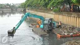 Alat berat dioperasikan petugas dari Dinas Kebersihan DKI untuk membersihkan sampah di kali yang berada di kawasan Cengkareng, Jakarta, Kamis (11/2). Kegiatan ini sebagai upaya Pemkot Jakarta Barat mengatasi banjir. (Liputan6.com/Faisal R Syam)