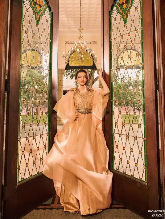 Ia mengenakan gaun satin panjang dengan detail payet berwarna nude yang terlihat glamor [@doleytobing]