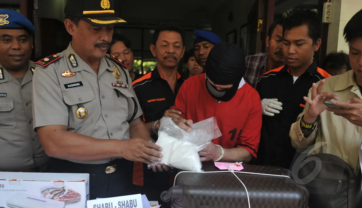 Kapolsek Senen Kompol Kasmono dan tersangka kasus narkotika saat perilisan barang bukti di Polsek Senen, Jakarta, Senin (6/4/2015). Polisi berhasil mengamankan 2 kg shabu dari warga kenegaraan Iran, Hajinasiri Mohsen Aliasgharr. (Liputan6.com/Johan Tallo)