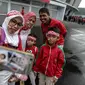 Satu keluarga suporter Timnas Indonesia berpose di depan Stadion Gelora Bung Karno (GBK), Senayan, Jakarta, Minggu (14/1). Menghadapi Islandia, Timnas Indonesia akan didominasi oleh pemain U-23. (Liputan6/Faizal Fanani)