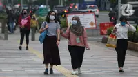 Warga mengenakan masker berjalan di pedestrian Jalan Jenderal Sudirman, Jakarta, Kamis (5/11/2020). BPS mencatat ekonomi Indonesia pada kuartal III-2020 minus 3,49 persen, Indonesia dipastikan resesi karena pertumbuhan ekonomi dua kali mengalami minus. (Liputan6.com/Helmi Fithriansyah)