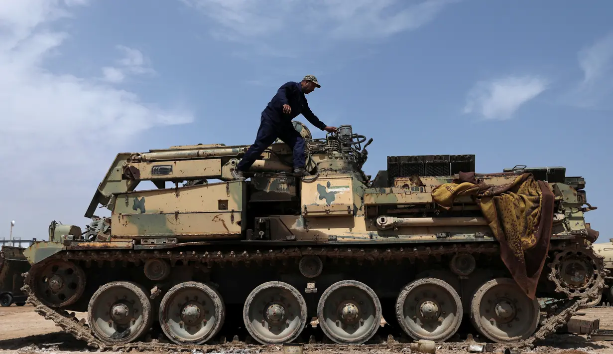 Seorang teknisi militer Pasukan Mobilisasi Populer Irak (Hashid Shaabi) mengecek tank yang rusak di sebuah bengkel di Kerbala, Irak (7/5). Bengkel ini menjadi salah satu lokasi perbaikan kendaraan-kendaraan militer rusak usai dipergunakan untuk perang. (Reuters/Abdullah Dhiaa Al- Dien)