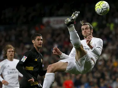 Aksi gelandang Real Madrid, Gareth Bale (kanan) menendang bola pada pertandingan melawan Sevilla di Liga Spanyol di Stadion Santiago Bernabeu (21/3). Real Madrid menang besar atas Sevilla dengan skor 4-0. (REUTERS/Sergio Perez)