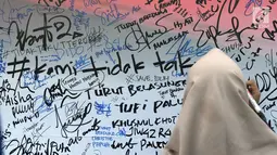 Pengunjung menuliskan dukungan buat Polri pasca kerusuhan di Rutan cabang Salemba Mako Brimob saat acara Car Free Day di Kawasan Bundaran Hotel Indonesia, Jakarta, Minggu (13/5). (Liputan6.com/Helmi Fithriansyah)