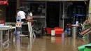 Beberapa karyawan memindahkan barang usai banjir di Jalan Kemang Raya, Minggu (28/8). Sejumlah kendaraan terendam air di kawasan Kemang Raya pasca hujan deras di Jakarta pada Sabtu (27/8). (Liputan6.com/Helmi Fithriansyah)