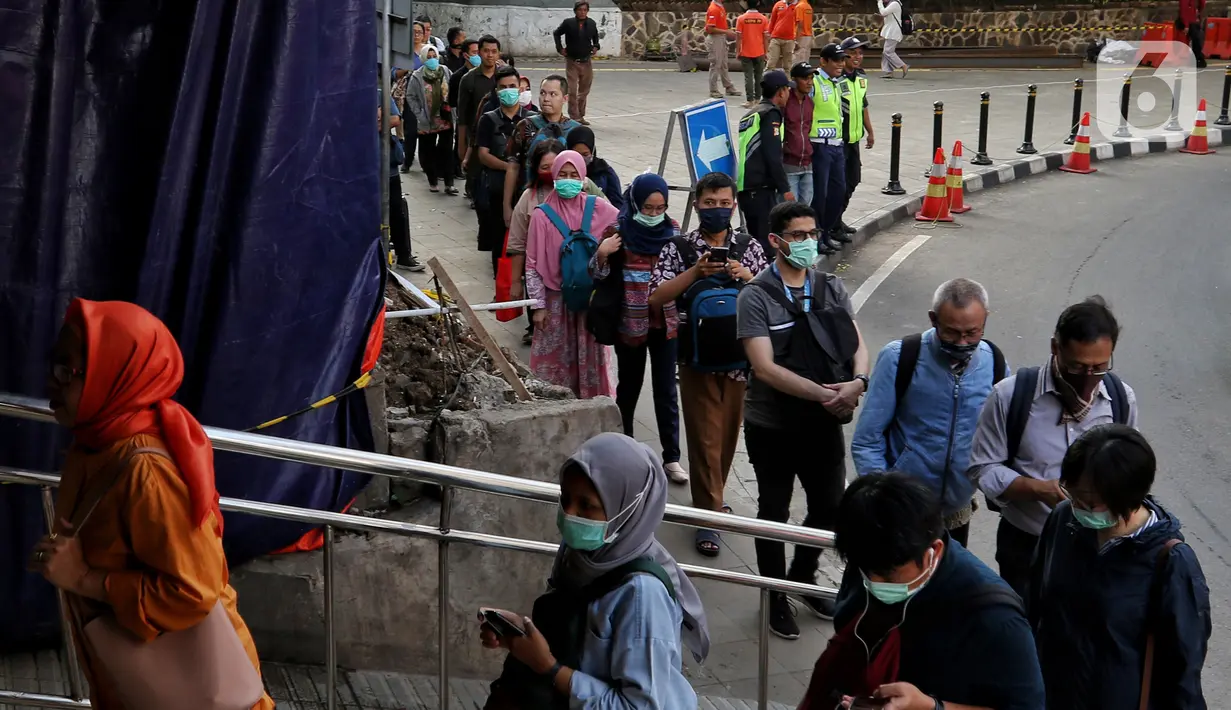 Antrean calon penumpang KRL Commuter Line untuk memasuki Stasiun Sudirman, Jakarta, Selasa (17/3/2020. Terjadi antrean akibat PT Kereta Commuter Indonesia (KCI) memberlakukan kebijakan pengecekan suhu tubuh bagi penumpang KRL mengantisipasi penyebaran virus corona Covid-19.\ (Liputan6.com/Johan Tall