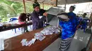 Petugas KPPS mengeluarkan  surat suara yang akan dihitung di TPS 17 Wukirsari,Cangkringan,Sleman, (9/12). KPUD Kabupaten Sleman menyelengarakan Pemilukada dengan kandidat dua pasang calon bupati dan wakil bupati periode 2015-2020.(Boy Harjanto)