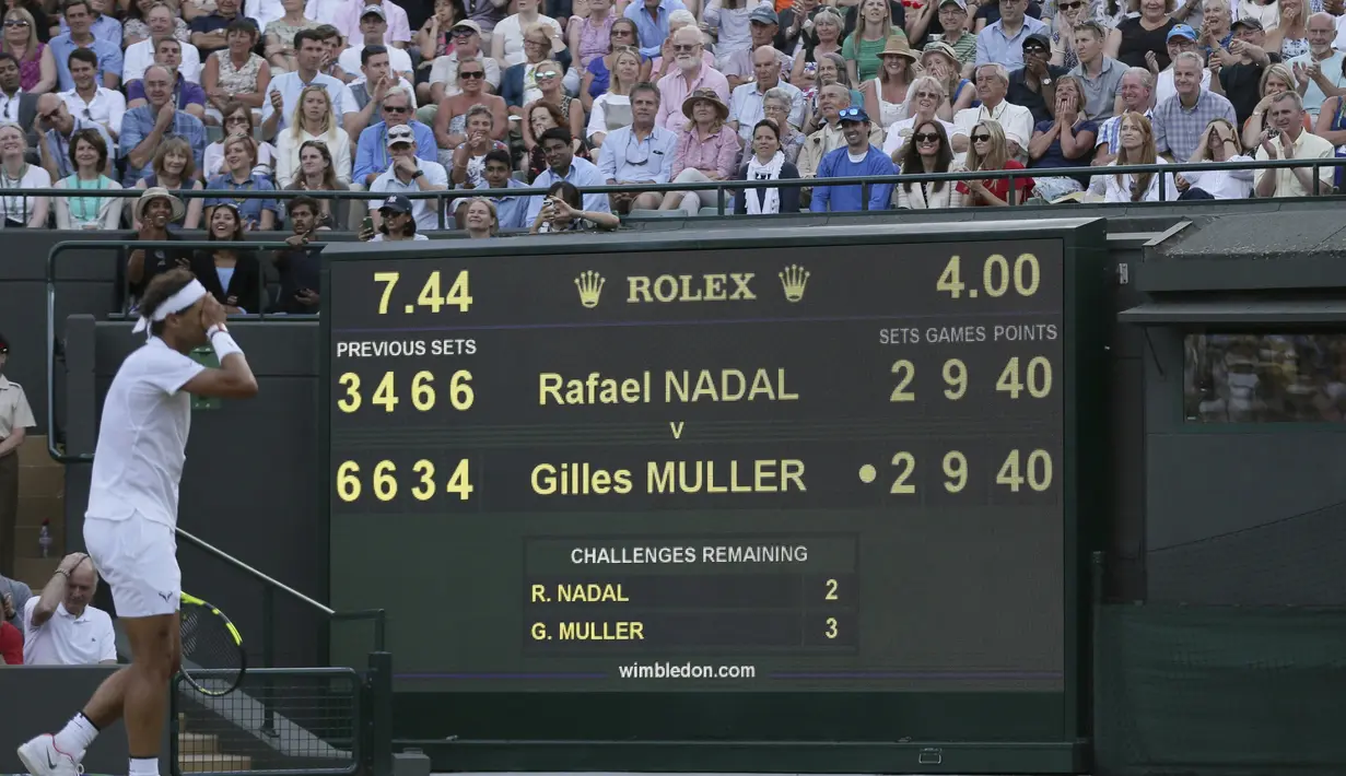 Rafael Nadal menutup wajahnya saat gagal meraih poin melawan Gilles Muller pada hari ketujuh di Wimbledon Tennis Championships 2017, London (10/7/2017). (AP/Tim Ireland)