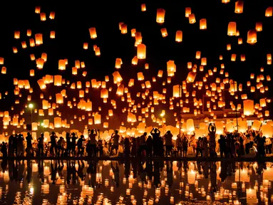 Sejumlah orang melepaskan lampion ke udara saat mereka merayakan festival Yee Peng di Chiang Mai (3/11). Dalam festival ini, ratusan bahkan ribuan orang beramai-ramai menerbangkan lampion ke udara. (AFP Photo/Roberto Schmidt)