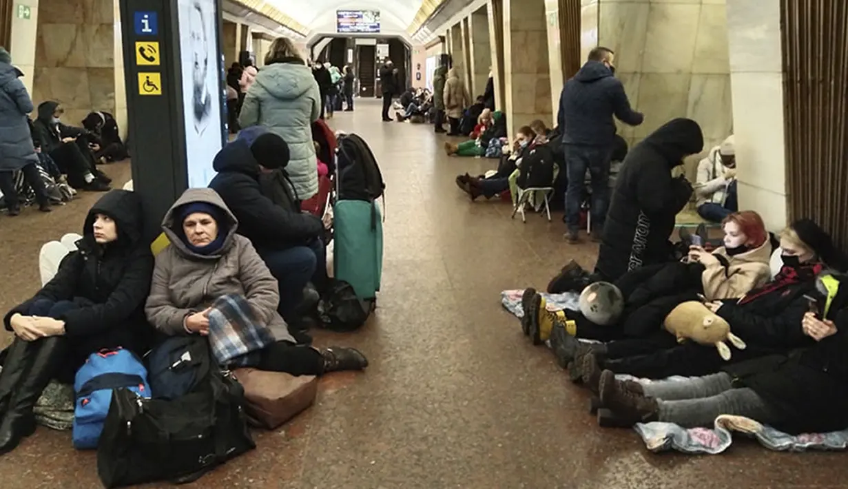 Orang-orang duduk di kereta bawah tanah Kiev, menggunakannya sebagai tempat perlindungan bom di ibu kota Ukraina, Kamis, 24 Februari 2022. Warga di Kiev tampak berlindung di stasiun bawah tanah kota dan tempat-tempat aman lainnya untuk menghindari invasi Rusia. (AP Photo/Emilio Morenatti)
