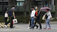Warga memakai masker untuk melindungi diri dari penyebaran COVID-19 di Taipei, Taiwan, Sabtu (15/5/2021). Taiwan yang telah berhasil membuat iri dalam menahan COVID-19 memberlakukan pembatasan baru di ibu kotanya saat memerangi wabah terburuk sejak pandemi dimulai. (AP Photo/Chiang Ying-ying)