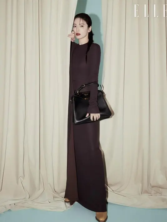 Song Hye Kyo tampil bak model profesional kenakan crewneck dress lengan panjang warna cokelat tua. Dipadu dengan tas hitam dari Fendi dan sepatu cokelat [@kyo1122]