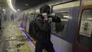 Seorang siswa menggunakan linggis merusak sebuah kereta di dalam stasiun MTR Universitas China di Hong Kong (13/11/2019). Gerakan antipemerintah Hong Kong yang telah berlangsung selama lima bulan bertindak semakin keras. (AP Photo/Kin Cheung)