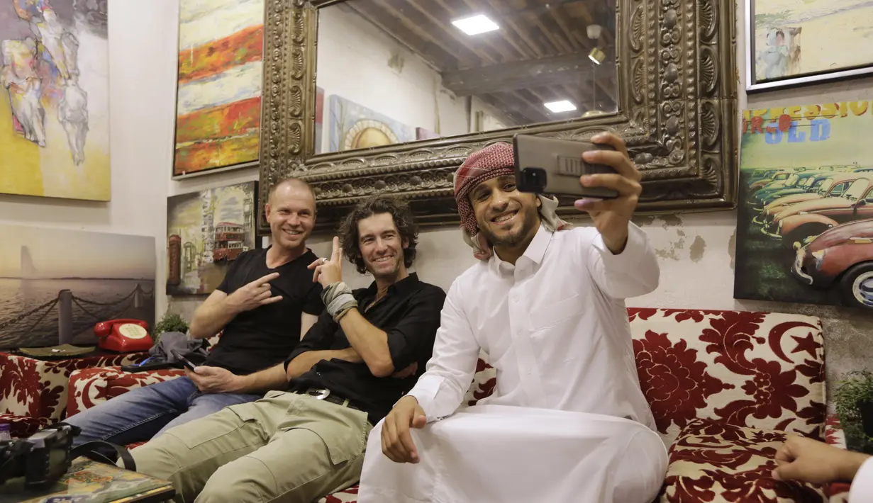 Pengunjung Jerman berfoto bersama pemilik toko Saudi di Kota Tua Jeddah, Arab Saudi (8/11/2021). Awal mula sejarah keberadaan kota Jeddah ini merupakan pintu masuk ke Makkah dan Madinah. (AP Photo/Amr Nabil)