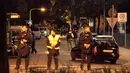 Petugas kepolisian berdiri di sebuah jalan kecil menyusul penembakan di pusat perbelanjaan Olympia di Munich, Jerman (22/7). Kepolisian menyatakan penembakan dilakukan oleh seorang remaja blasteran Jerman-Iran berusia 18 tahun.  (REUTERS/Christian Mang)