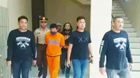 Rohmad Tri Hartanto, pelaku mutilasi wanita dalam koper merah di Ngawi saat digelandang polisi. (Liputan6.com/ Dian Kurniawan)