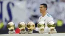 Bintang Real Madrid, Cristiano Ronaldo, berpose dengan kelima trofi Ballon d'Or di Stadion Santiago Bernabeu, Sabtu (9/12/2017). Cristiano Ronaldo meraih Ballon d'Or 2017 setelah unggul dari Lionel Messi dan Neymar. (AP/Francisco Seco)