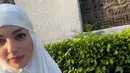 Nia Ramadhani merayakan Iduladha di Singapura, ia pun mengenakan mukena putih polos. Wajahnya dipulas blush on pink serta lipstik tipis. [@ramadhaniabakrie]