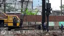 Alat berat dikerahkan untuk memasang pasak di bantaran Kali Ciliwung, Bukit Duri, Jakarta (1/11). Pemasangan tiang pancang untuk sheet pile di kali tersebut ditargetkan hingga 2000 meter dan selesai akhir Desember 2016. (Liputan6.com/Gempur M Surya)