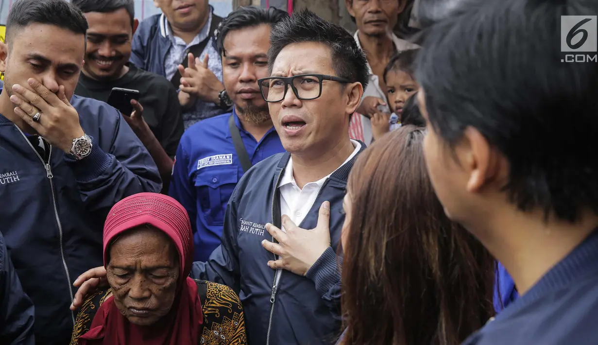 Artis sekaligus Ketua DPW PAN DKI Jakarta Eko Patrio bersama para pekerja seni berbincang dengan salah satu warga saat menyambangi lokasi kebakaran di Taman Sari, Jakarta, Senin (5/2). (Liputan6.com/Faizal Fanani)