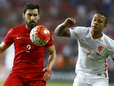 Bek Turki, Sener Ozbayrakli (kiri) berebut bola dengan penyerang Belanda, Memphis Depay pada kualifikasi Grup A Euro 2016 di Konya, Turki, (6/9/2015). Turki menang atas Belanda dengan skor 3-0. (REUTERS/Umit Bektas)