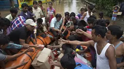 Petugas membagikan makanan kepada korban banjir di Gauhati, India, Rabu (14/6). Angin monsun yang mendatangi India berdampak pada tingginya curah hujan yang menyebabkan banjir. (AP Photo / Anupam Nath)