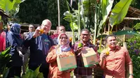 Sekretaris Badan Penyuluhan dan Pengembangan SDM Pertanian Kementerian Pertanian, Siti Munifah, tengah menunjukan cenderamat berupa buah-buahan segar di perkebunan Eptilu, Garut, Jawa Barat, Sabtu. (Liputan6.com/Jayadi Supriadin)