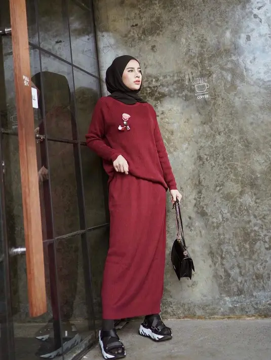 Tampilan feminin selebgram Aghnia Punjabi, cukup padukan set rib sweater dan skirt warna merah. Untuk hijab, pilih warna hijab. Sesuaikan dengan sandal dan task amu! (Instagram/emyaghnia).