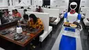 Sebuah robot mengantarkan pesanan makanan kepada pelanggan saat pembukaan restoran di Bangalore, India, Sabtu (17/8/2019). Setiap meja dilengkapi dengan tablet di mana pengunjung dapat memesan dan memanggil robot. (Manjunath Kiran/AFP)