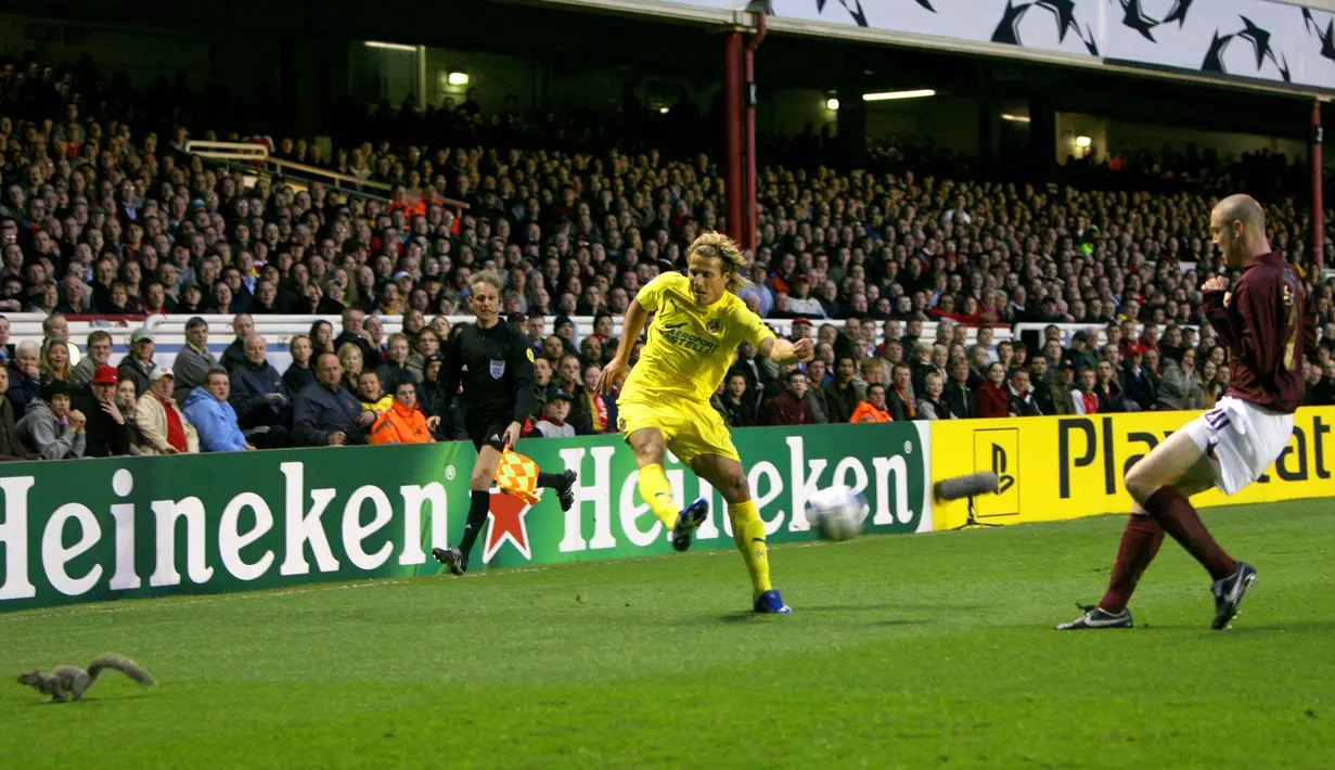 Seekor tupai tertangkap kamera berlari ke luar lapangan saat pemain bola Villarreal CF, Diego Forlan sedang mengontrol bola dalam pertandingan lanjutan Liga Champions melawan Arsenal di Stadion Highbury pada 19 April 2016 silam. (AP Photo/Tom Hevezi)
